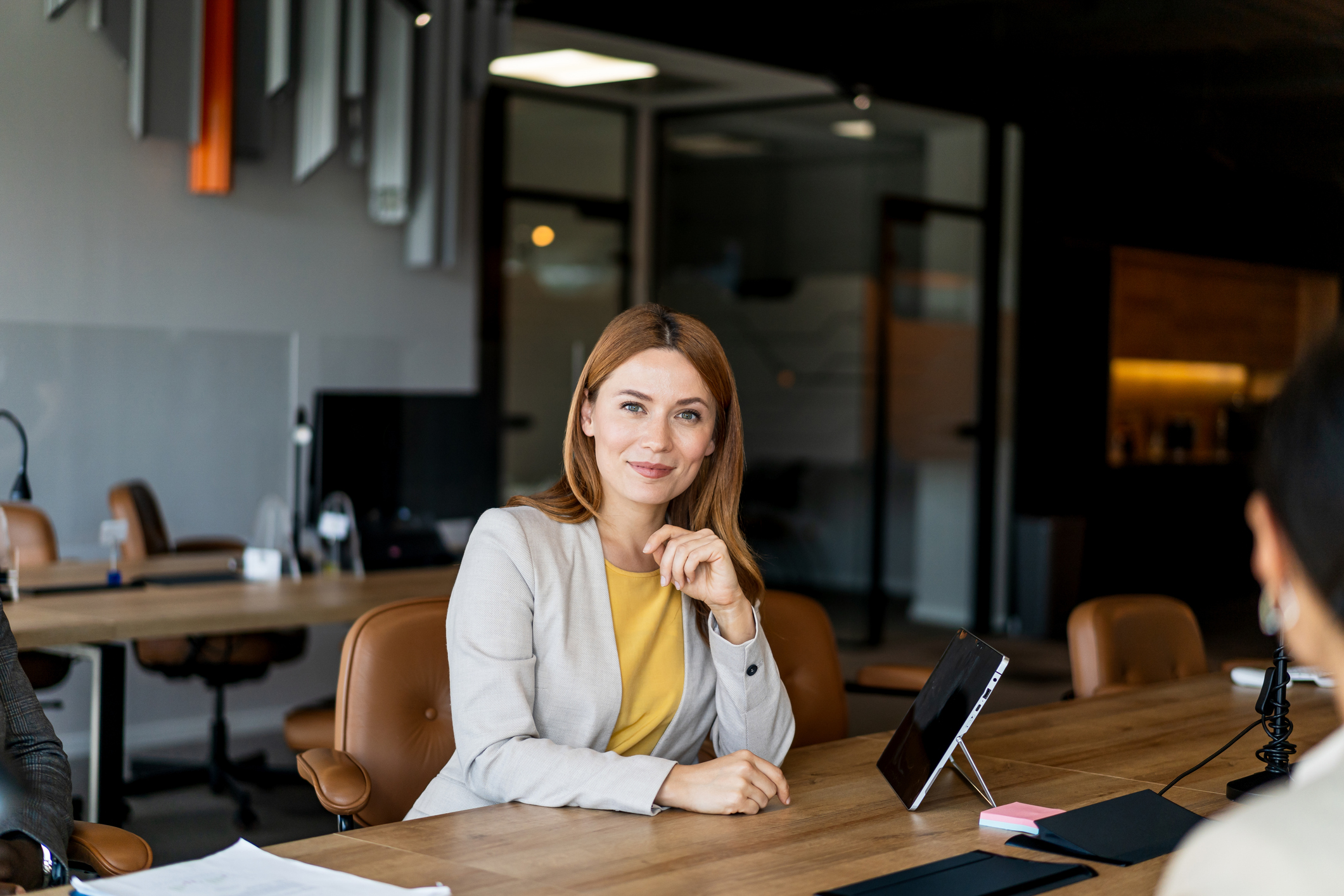 Smiling businesswoman seated at modern conference table