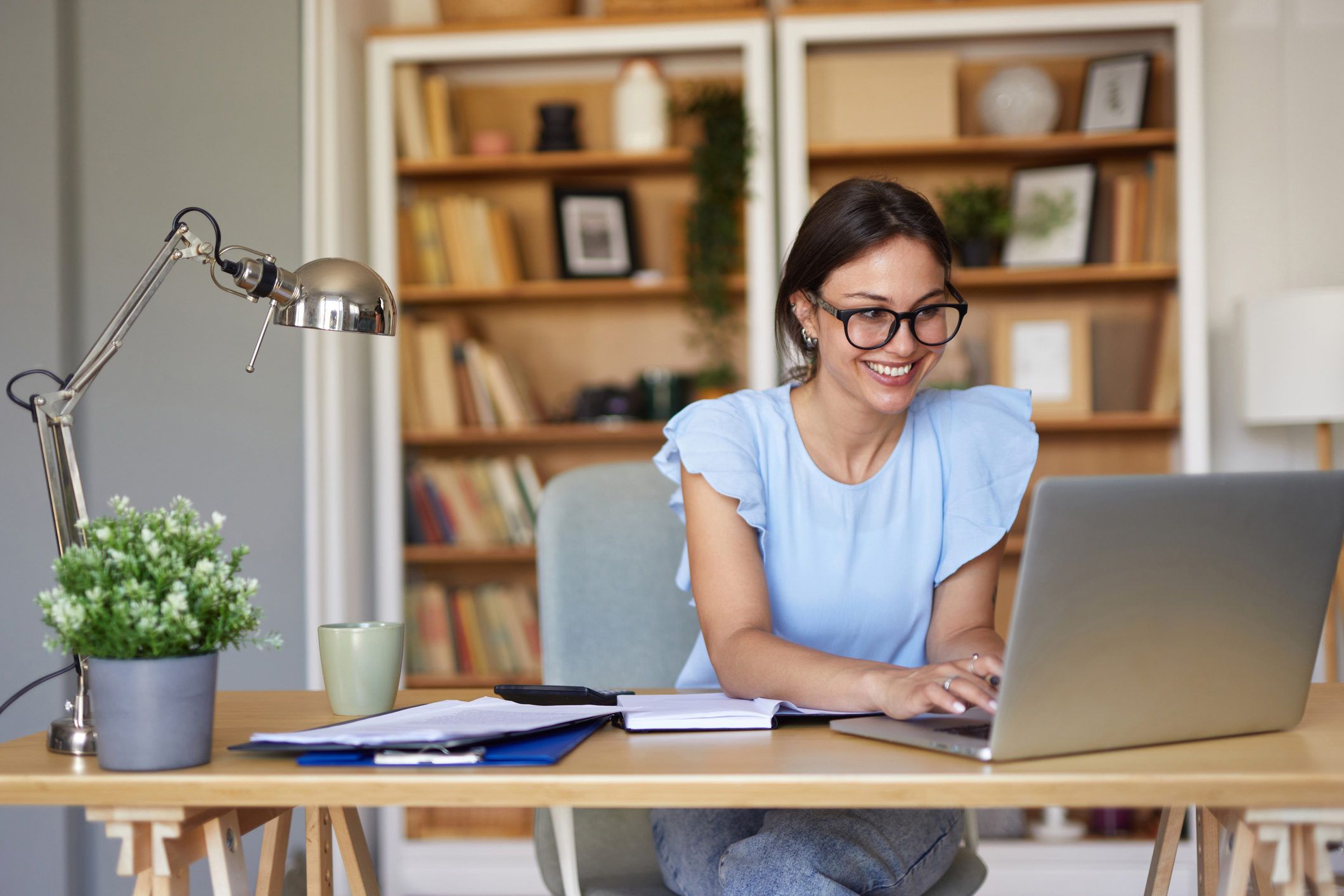Smiling woman working on laptop at desk