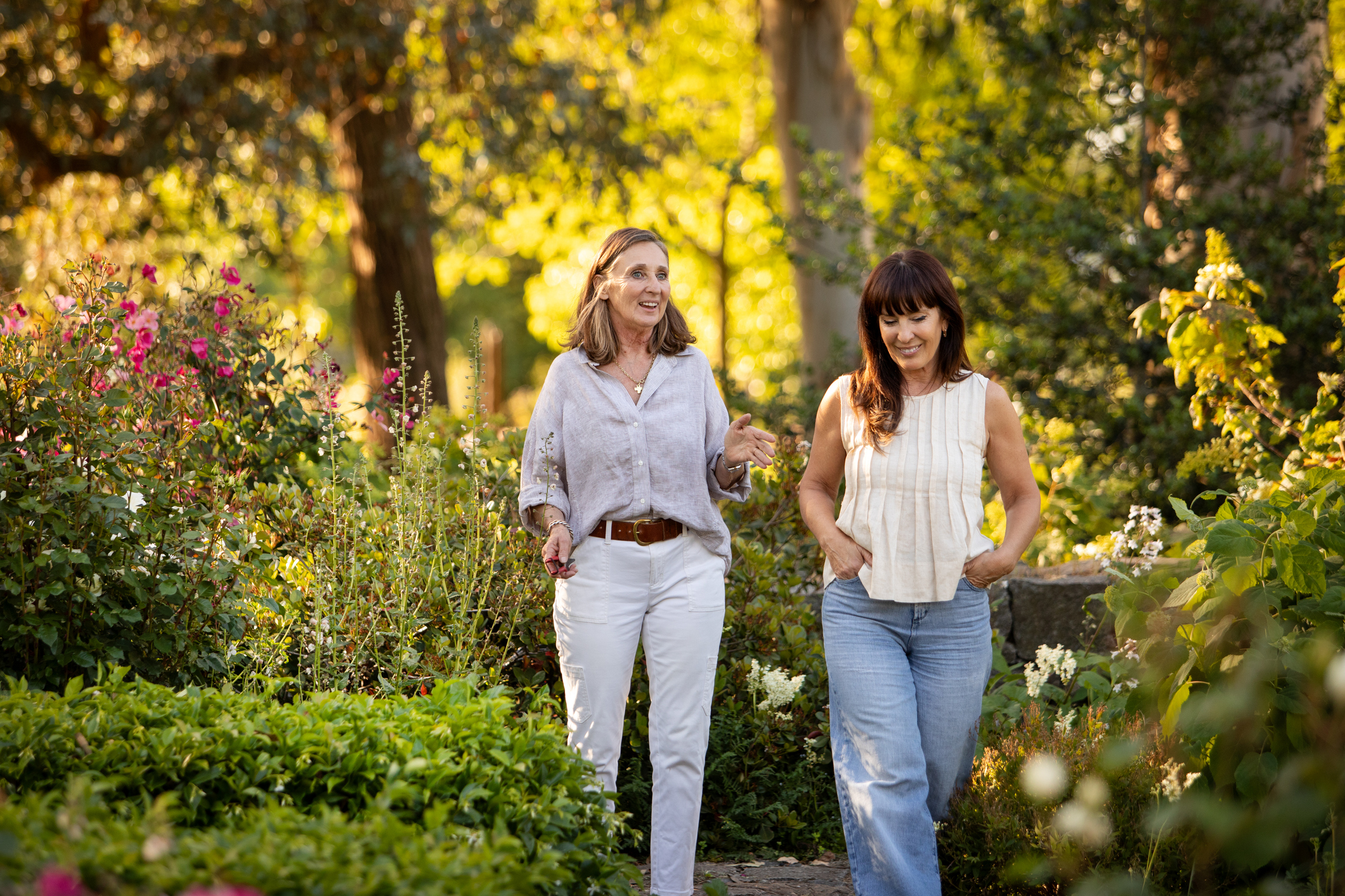 Two women walking and chatting in garden